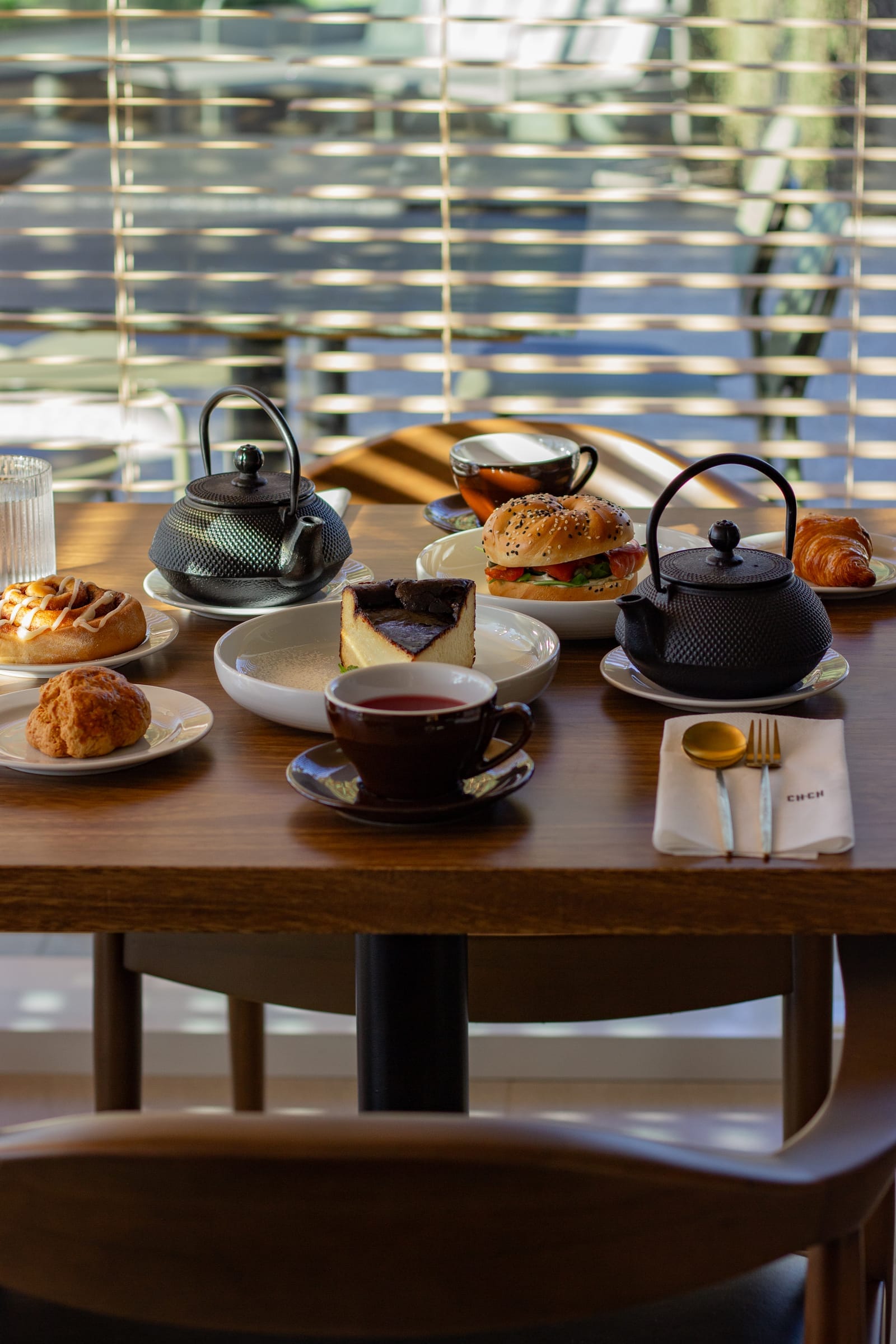 Servicio de té con teteras de hierro, sándwiches y pastelería